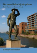 Bronzen beeld van een zeeman in een pet, die naar de horizon kijkt, met moderne gebouwen op de achtergrond.