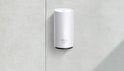 Witte Deco X50 Outdoor mesh wifi-unit aan een grijze muur bevestigd.