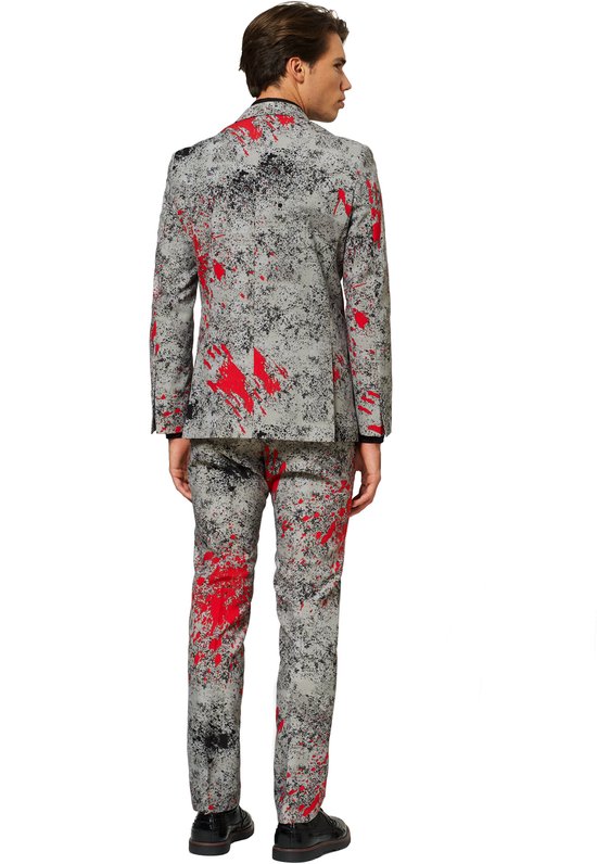 Man in een grijs OppoSuits 'Zombiac' kostuum met rode verfspatten, van achteren gezien. Het pak bestaat uit een jasje en broek.