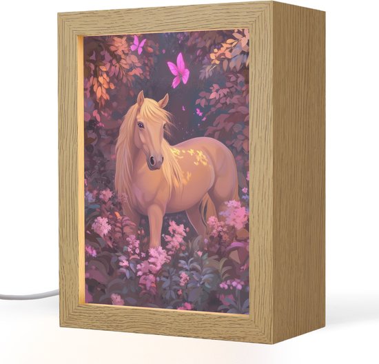 Een verlichte staande lamp met afbeelding van een goudkleurig paard in een bloemenveld, met paarse bloemen en vlinders, in een houten lijst.