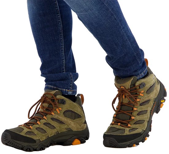 Merrell Moab 3 mid-hoog, olijfgroene suède en mesh wandelschoenen met oranje accenten en blauwe jeans.