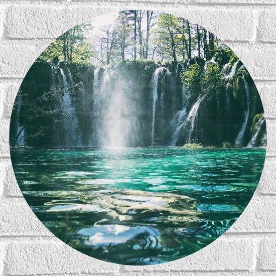 Cirkel met een waterval die in een turquoise meer valt, met weerspiegelingen en bomen op de achtergrond.