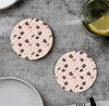 Twee ronde onderzetters met een roze terrazzo-patroon van bruine en beige spikkels.