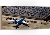 WallClassics - Hout - Blauw Vliegtuig op Vliegbasis - 100x50 cm - 12 mm dik - Foto op Hout (Met Ophangsysteem)