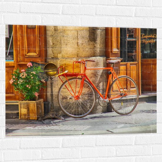 WallClassics - Muursticker - Oranje Fiets bij Stenen Gebouw - 100x75 cm Foto op Muursticker