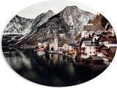 WallClassics - PVC Schuimplaat Ovaal - Klein Dorpje tussen Bergen bij Water - 68x51 cm Foto op Ovaal  (Met Ophangsysteem)