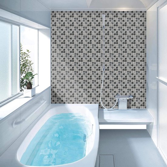 Salle de bain avec un mur carrelé de mosaïques en marbre noir et gris et une baignoire.