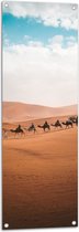 WallClassics - Tuinposter – Rij Kamelen in Woestijn - 40x120 cm Foto op Tuinposter  (wanddecoratie voor buiten en binnen)