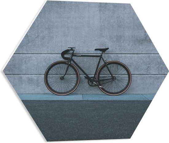 WallClassics - PVC Schuimplaat Hexagon  - Zwarte Fiets tegen Grijze Gebouw - 50x43.5 cm Foto op Hexagon (Met Ophangsysteem)