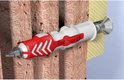 Rode en witte Fischer Duopower plug in een bakstenen muur met schroef.