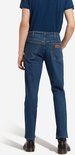 Blauwe Wrangler jeans, regular fit, gedragen met donkerblauw T-shirt en zwarte schoenen, van achteren gezien.