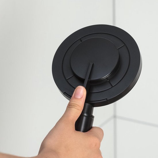 Hand houdt een matzwarte douchekop met een platte ronde bovenkant vast.