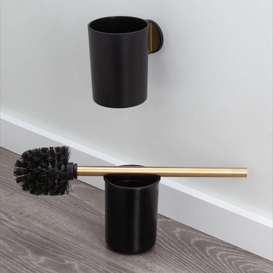 Support de brosse de toilette noir avec tige dorée, à côté de toilettes.