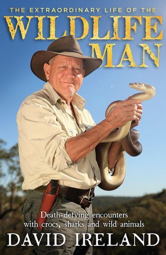 David Ireland met een bruine python in zijn handen. Hij draagt een beige safari-outfit met een bruine hoed.