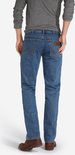 Achterkant van een blauwe regular fit jeans met bruine schoenen.