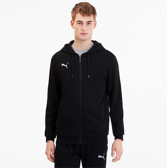 Man met zwarte Puma hoodie met rits, witte logo op borst, grijze shirt eronder.