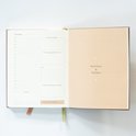 Planner met dagindeling links en een bruin getinte notitiepagina rechts.