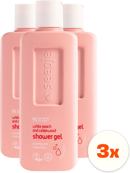 Drie lichtroze flessen Seepje douchegel met witte dop. Eén fles is op de voorgrond met tekst '99.1% natural origin white peach and cedarwood shower gel' en '3x'.