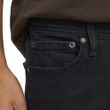 Sluiting van de zwarte denim jeans met zakken en klinknagels.