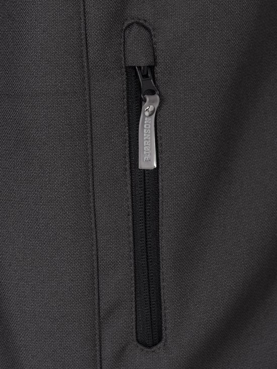 Close-up van een ritszak op een grijze softshell jas met Bjørnson-logo trekker.