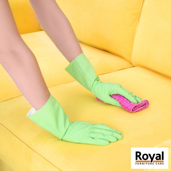 Groene handschoenen en een roze doek maken een gele bank schoon.