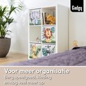 Een Kallax-kast met opbergdozen van olifant, leeuw, zebra en giraf, naast een bed in een kinderkamer.