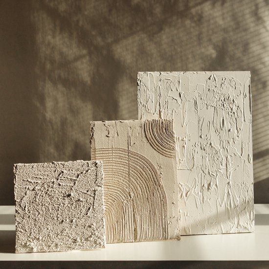 Drie textuurpanelen van crème kleur, verschillend in grootte en met verschillende textuurontwerpen.