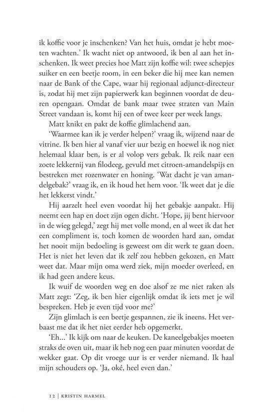 Een vrouw met donker haar, gekleed in een witte trui, staat met haar armen over elkaar en kijkt naar de camera.