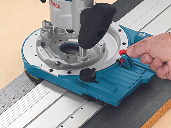Bosch GKF 600 bovenfrees, met hand op de vergrendeling.