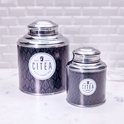 Twee ronde metalen theeblikken met CITEA logo en donkerblauw bladerenpatroon. De blikken hebben zilverkleurige deksels.