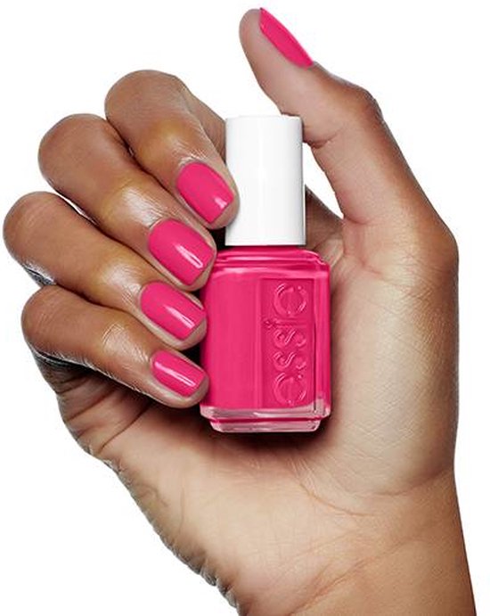 Donkere hand houdt essie nagellakflesje met felroze lak. Nagellak is felroze.