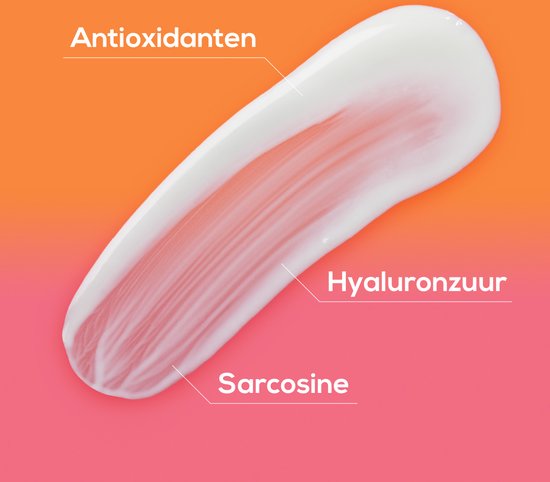 Een veeg witte crème, gelabeld met antioxidanten, hyaluronzuur en sarcosine, op een oranje/roze achtergrond.