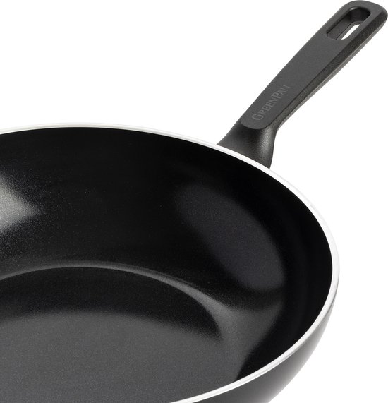 Close-up van een zwarte GreenPan wokpan met wit accent op de rand en zwart handvat.