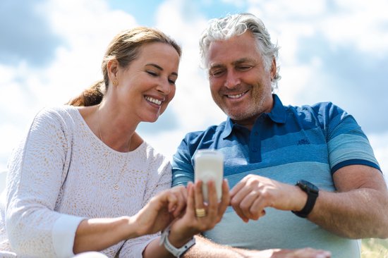 Man en vrouw met fietsen bekijken een apparaatje.