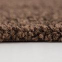 Een close-up van de bruine, shaggy pool van het vloerkleed.