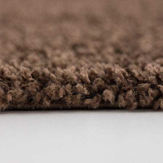 Een close-up van de bruine, shaggy pool van het vloerkleed.