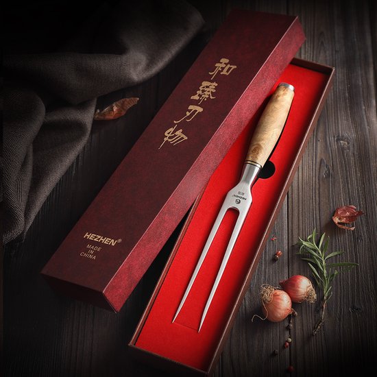 Fourchette à viande avec un manche en sycomore flammé poli brun clair dans une boîte cadeau rouge.
