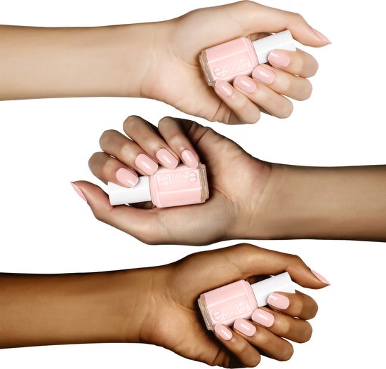Drie handen met lichtroze Essie nagellak, elk houdend een flesje Essie nagellak.