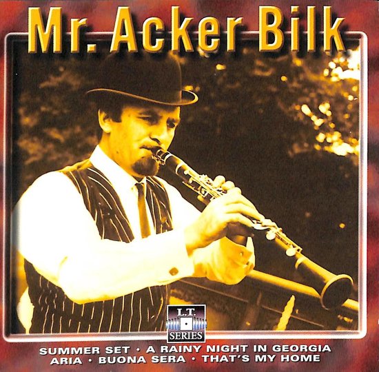 Mr. Acker Bilk, gekleed in een gestreept vest en hoge hoed, speelt klarinet.
