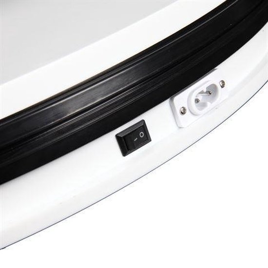 Close-up van een wit draaiplateau met zwarte rubberen rand, aan/uitknop en stopcontact.