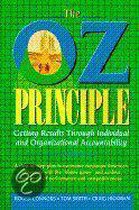Boek 'The Oz Principle' met blauwe letters en een afbeelding van gebouwen in de 'O'. Groene achtergrond met ruitjes.