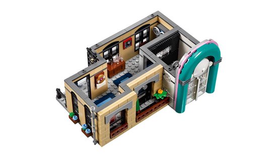 LEGO gebouw met een jukebox, bureau, en een slaapkamer met rood bed.