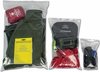 Drie transparante afsluitbare zakken met daarin een legergroene jas, een geel notitieboekje, een rode EHBO-kit, een opvouwbare rugzak, een rode sjaal en zwarte sokken.