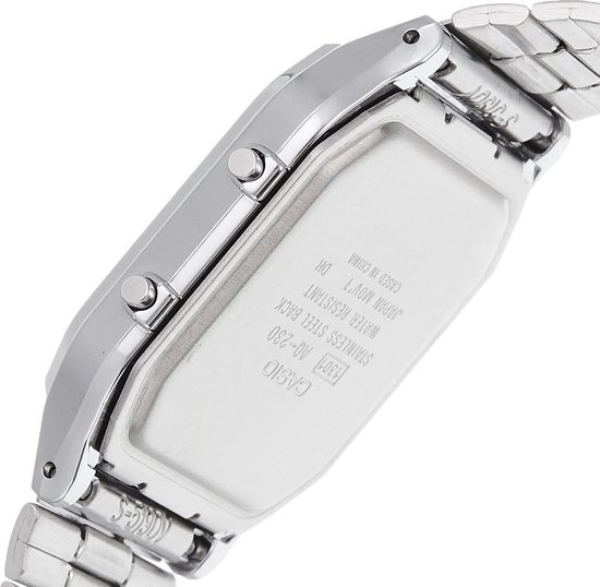 Profil latéral d'une montre argentée avec bracelet métallique, couvercle gravé et bracelet argenté.