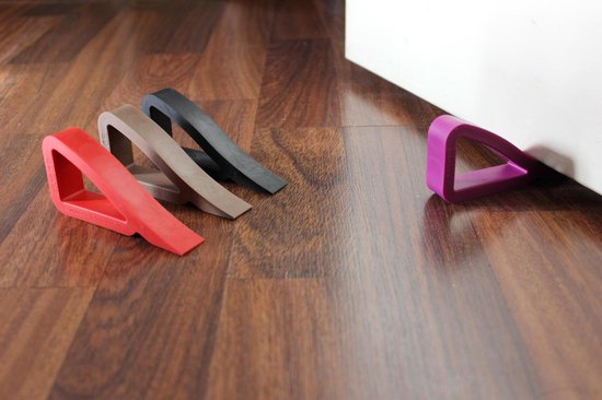 Deurcdotoren in rood, bruin, zwart en paars op een houten vloer naast een witte deur.