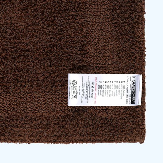 Bruine badmat met label: 100% katoen