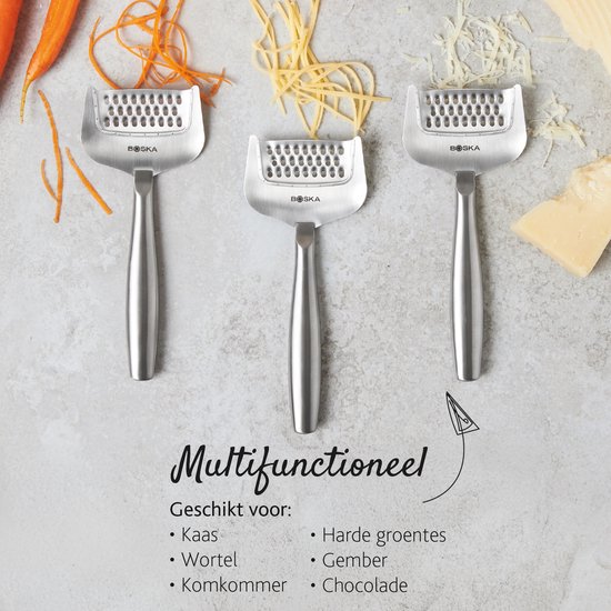 Trois râpes à fromage argentées avec poignées ergonomiques, à côté de carottes et de gingembre.