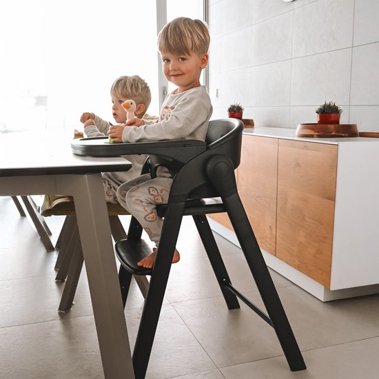 Zwarte Deryan kinderstoel met twee jongens aan tafel.