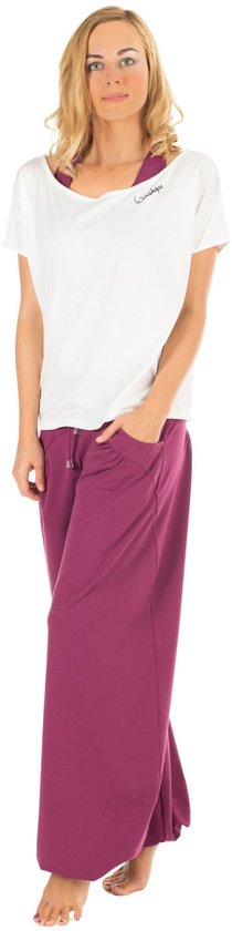 Model in witte off-shoulder top met 'Winshape' logo en paarse wijde broek.