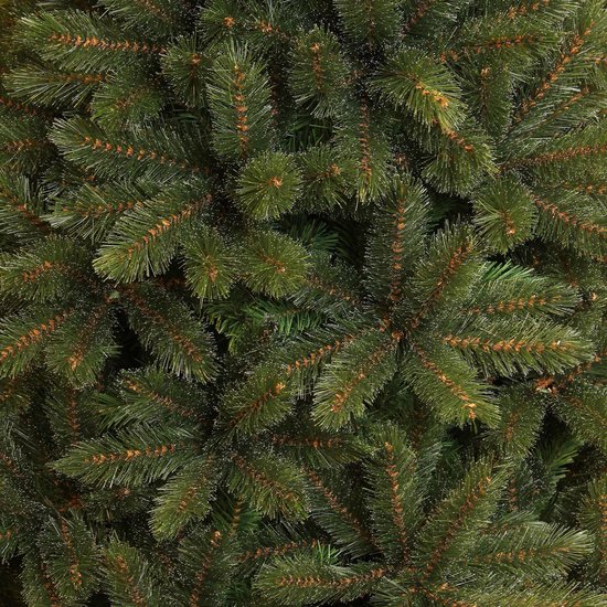 Volledige opname van dichte, groene kerstboomtakken met bruine stengels en fijne witte puntjes.
